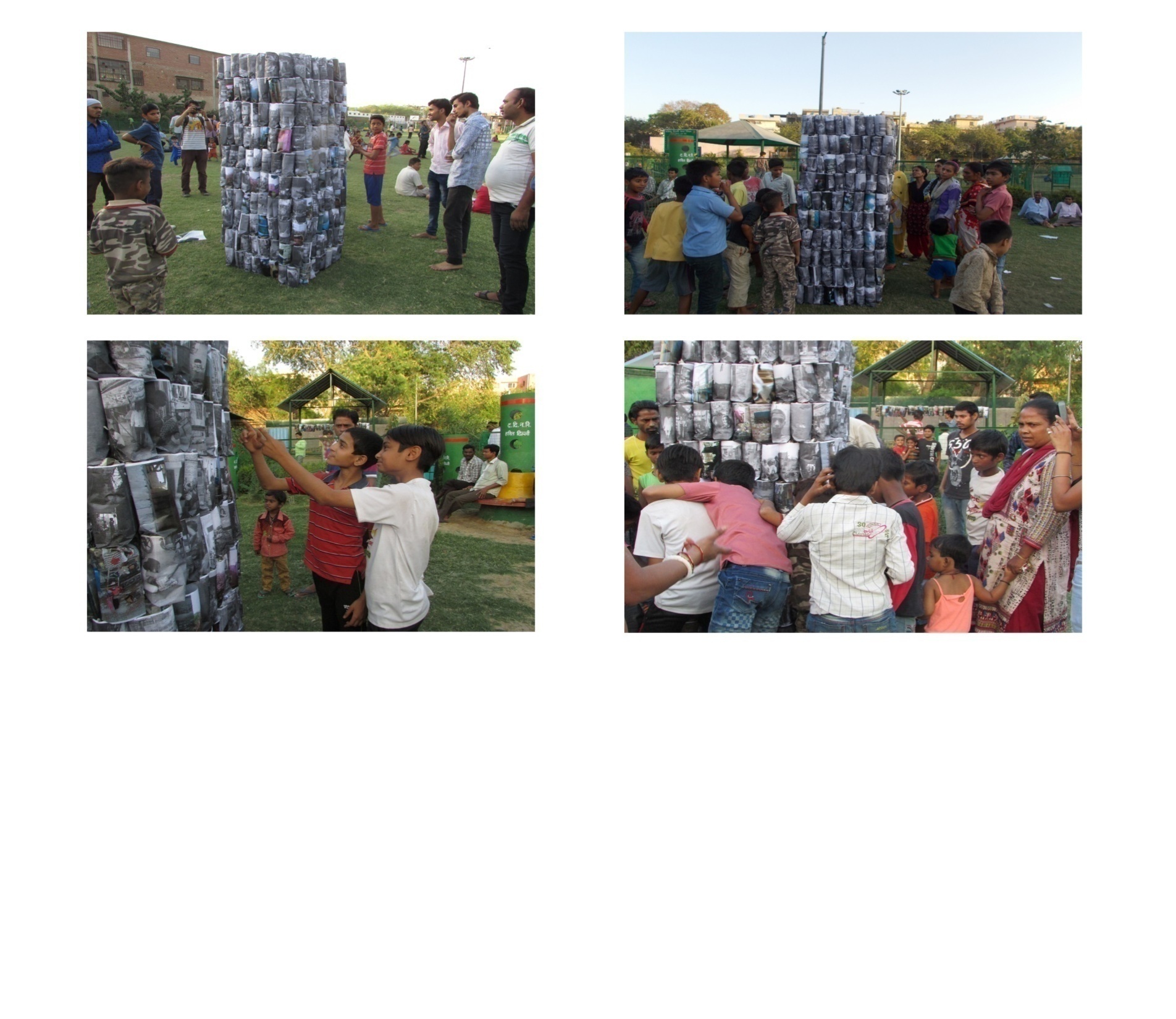 Thonga, final day public display at Open Ground, Govindpuri, New Delhi, 2017. Community members — adults and children — gather around two large tower-form installations constructed entirely from handmade Thongas printed with photographs of their own homes.